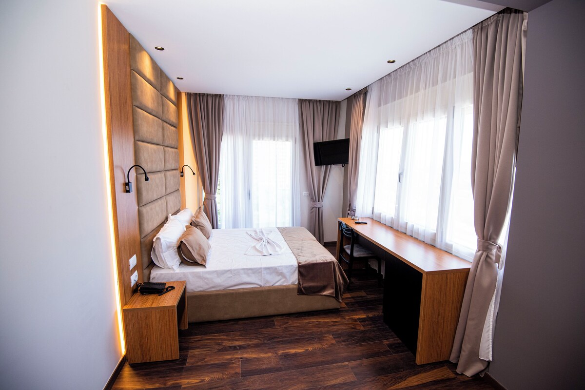 Une chambre d’hôtel moderne équipée d’un lit, d’un bureau et d’une télévision.