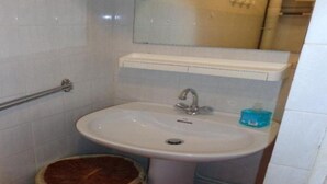 A small bathroom with a white sink, a mirror above it, and a wooden stool. - Charming Studio for 2 with Parking, Near Thermal Baths and City Center (Amélie-les-Bains-Palalda)