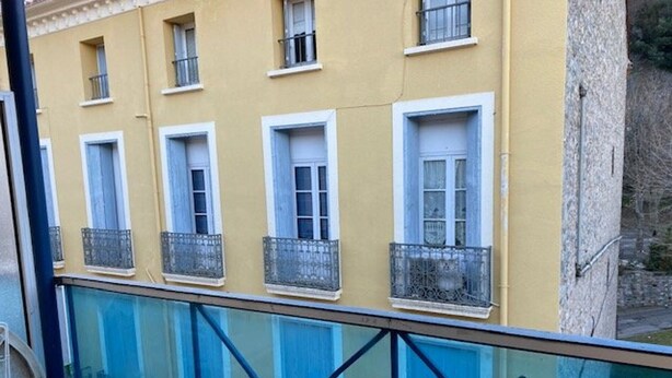 A yellow building with multiple windows and balconies. - Charming Studio for 2 with Parking, Near Thermal Baths and City Center (Amélie-les-Bains-Palalda)