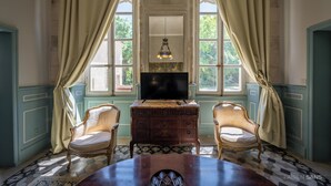 A room with a wooden desk, two chairs, a television, and large windows with curtains. - Charming 18th century house entirely renovated (Pexiora)