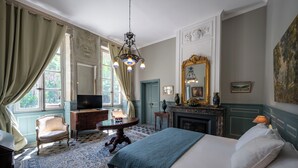 A classic room with a bed, a television, a fireplace, and a large mirror. - Charming 18th century house entirely renovated (Pexiora)