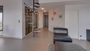 A modern interior with a staircase, a sofa, and artwork on the walls. - Châtelaillon-Plage: 4-room apartment, 6 people, terrace, WIFI (Châtelaillon-Plage)