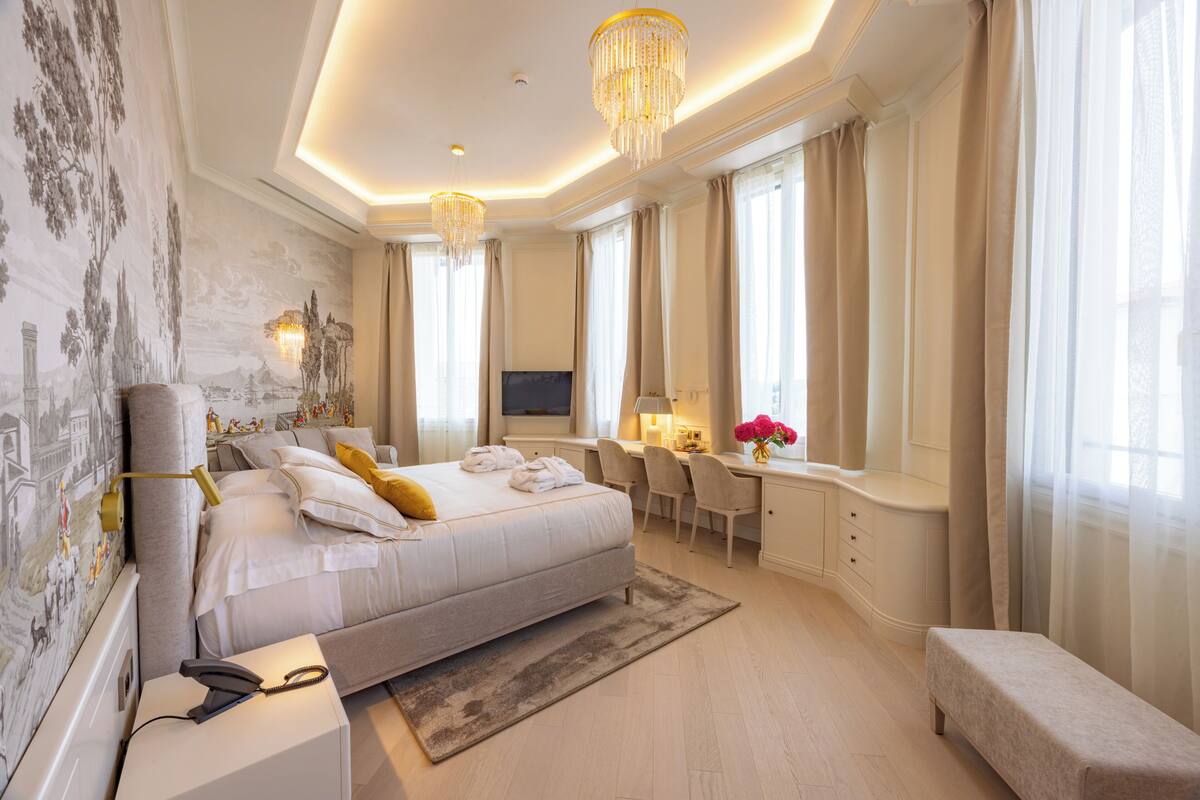 Une chambre d’hôtel moderne, dotée d’un grand lit, d’un bureau et d’une télévision.