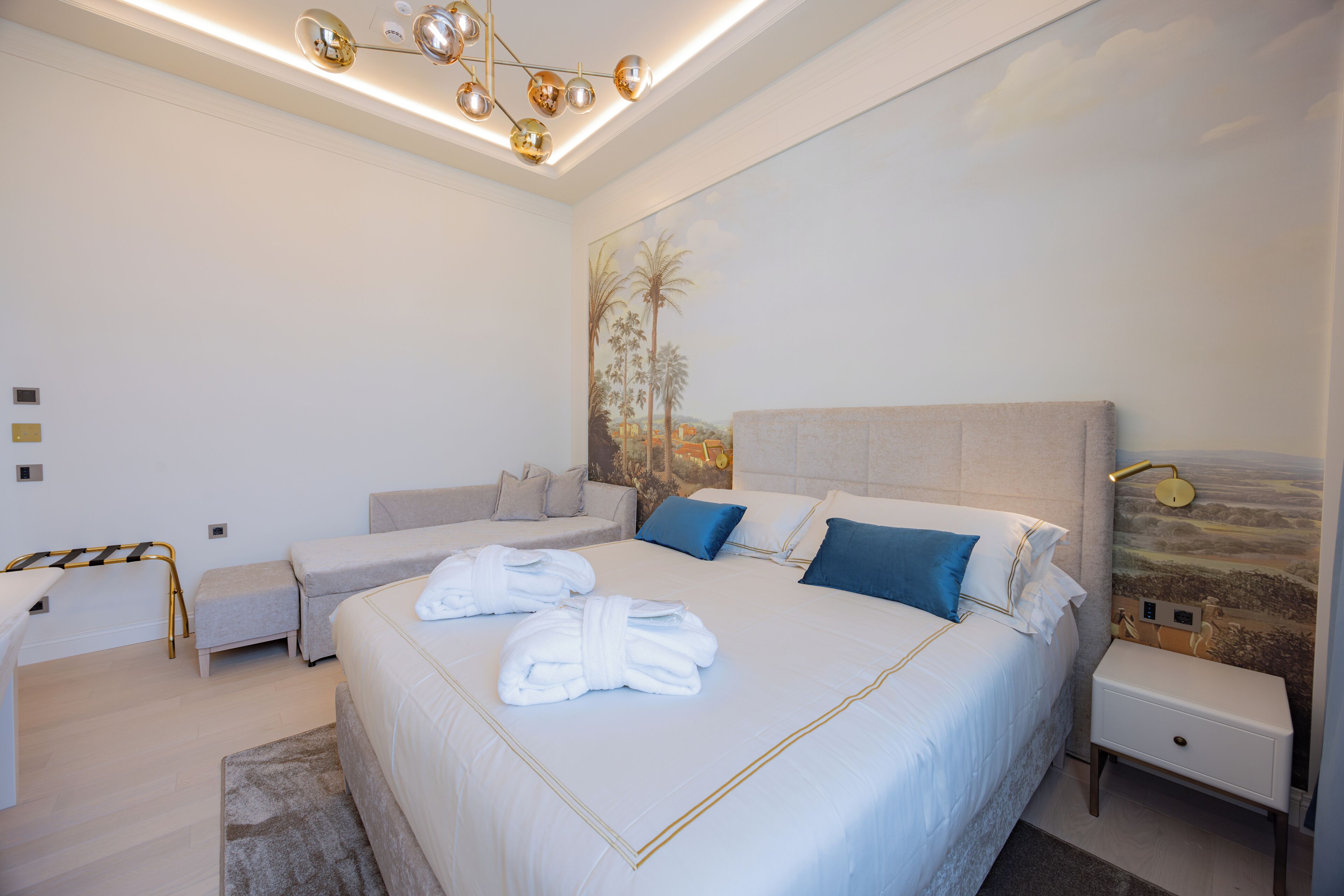 A modern bedroom with a large bed, bedside tables, and a ceiling light fixture.