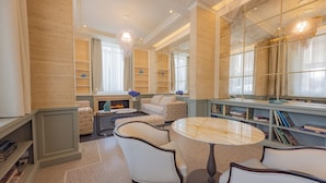 A spacious living room with a fireplace, comfortable seating, and a large bookshelf.