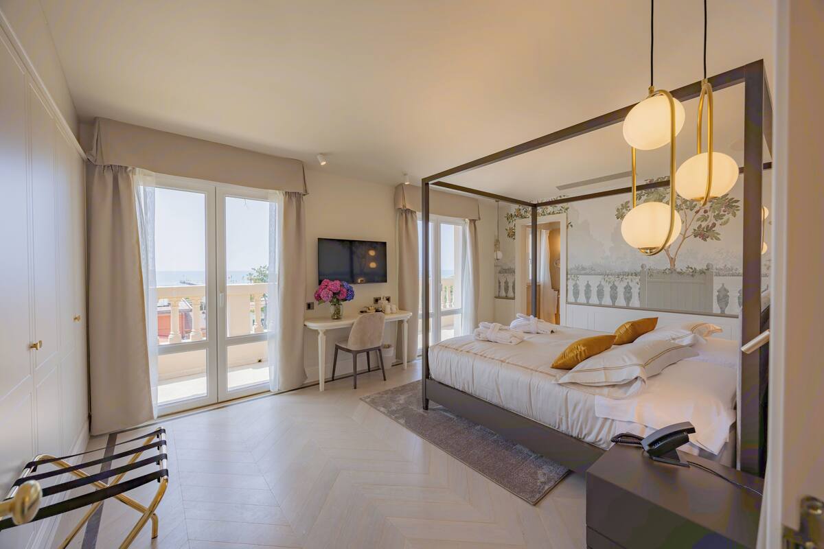 Une chambre moderne avec un grand lit, un bureau et une vue par la fenêtre.