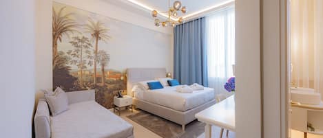 A modern hotel room with a bed, a sofa, a dining table, and a painting on the wall.
