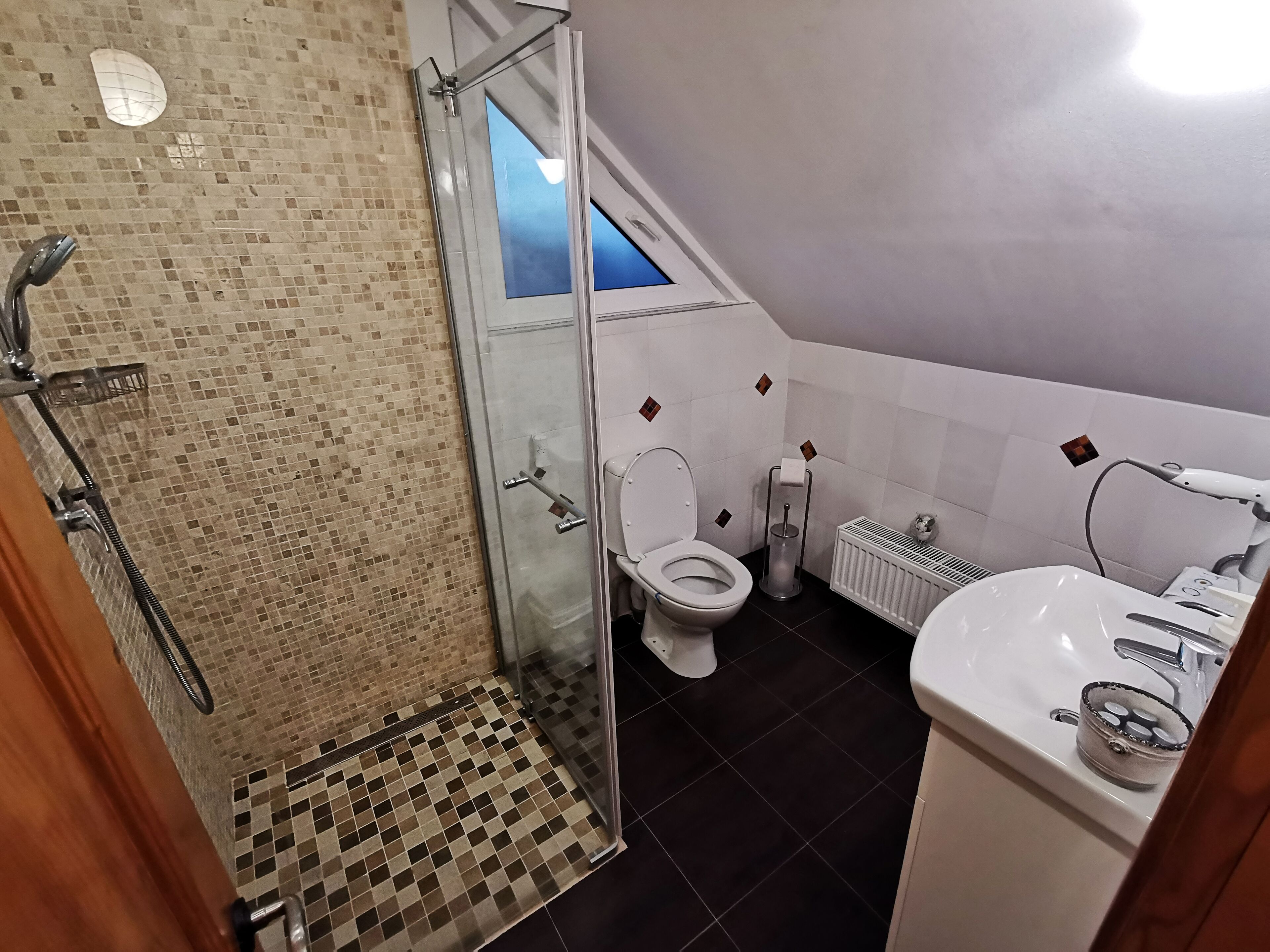 A bathroom with a shower, toilet, and sink.