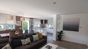 A modern living room with a sofa, coffee table, and dining area with chairs. - MARKAIDA HOUSE WITH POOL (Mungia)