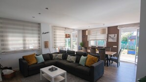 A modern living room with a sectional sofa, a coffee table, and a dining area with a table and chairs. - MARKAIDA HOUSE WITH POOL (Mungia)