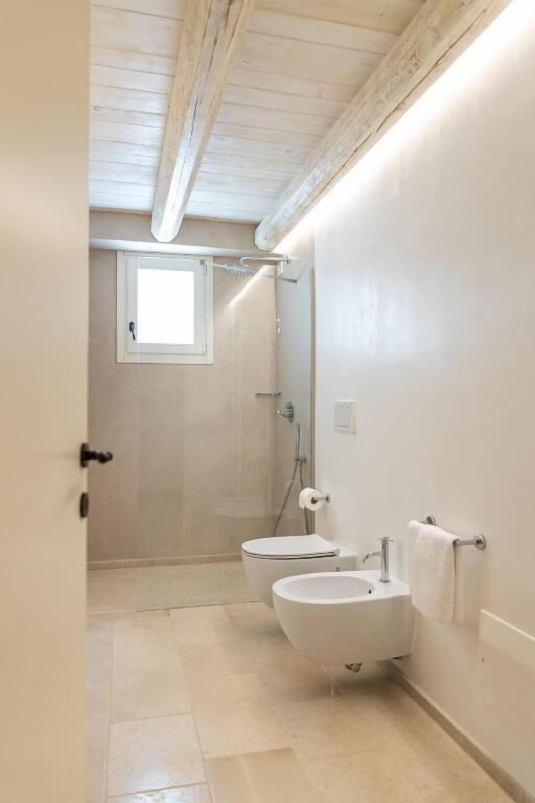 Un baño con inodoro, bidé y lavamanos.