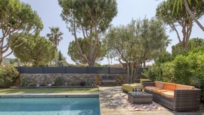 A pool area with a wooden deck, outdoor furniture, and a stone wall. - la Choupette by Interhome (Saint Cyr sur mer Les Lecques)