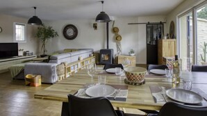 A modern living room with a sofa, a TV, and a dining area set with a wooden table and chairs. - la Choupette by Interhome (Saint Cyr sur mer Les Lecques)