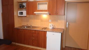 Kjøleskap, mikrobølgeovn, kjøkkenutstyr og spisebord