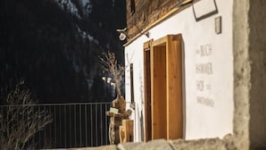 A rustic building with a wooden door and a sign that reads "BUCH HAMMER OF". - David am Buchhammerhof by Interhome (Kaunerberg)