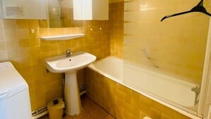Un baño con lavamanos, espejo y bañera.