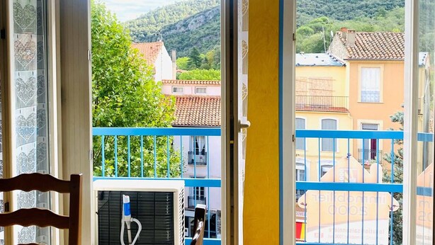 Un balcón con vista a una colina y edificios.