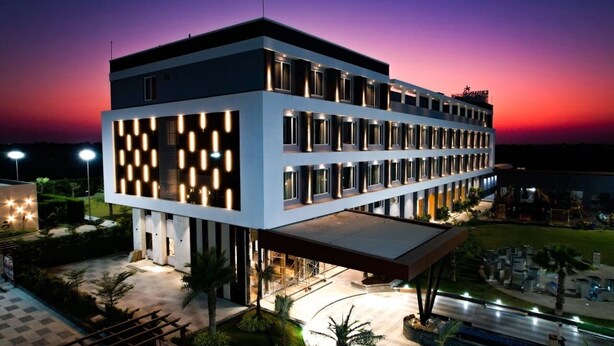 Un hôtel à plusieurs étages, doté d’un design moderne, avec un toit plat et une façade ornée de motifs.