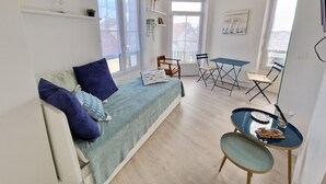 En kompakt opholdsstue med sofa, spisebord og stol.