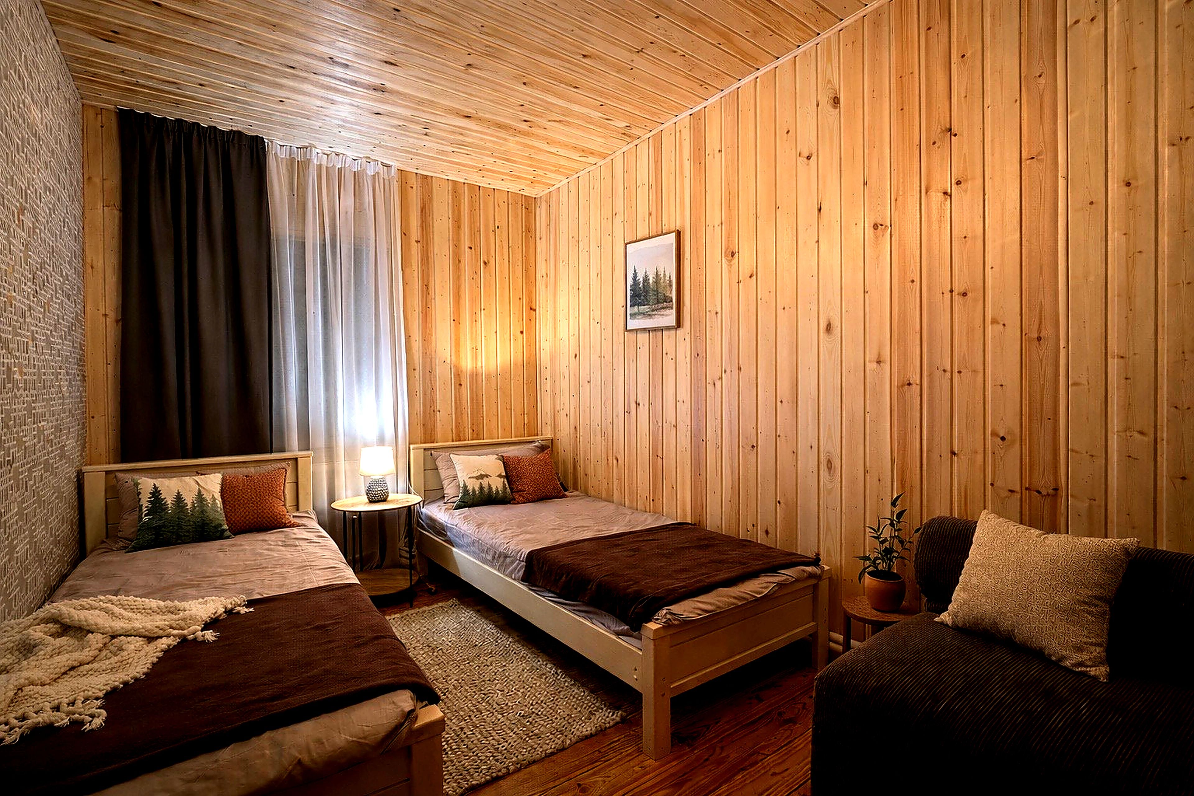 A wooden-paneled room with two beds, a nightstand, a lamp, and a framed picture on the wall.
