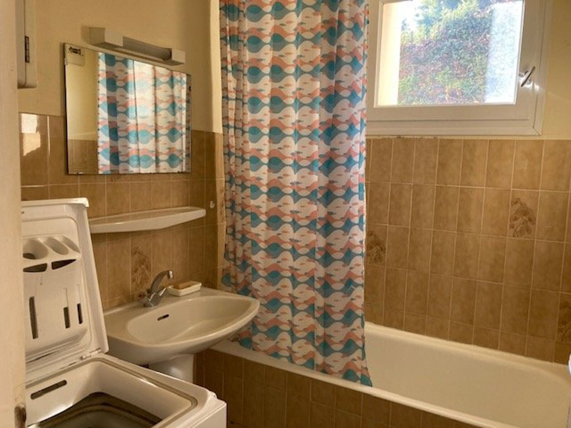 A bathroom with a bathtub, a sink, and a mirror.