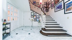 A staircase with a white railing and a series of framed pictures on the walls. - Beaux-Arts house in Condesa with rooftop (Ciudad de México)