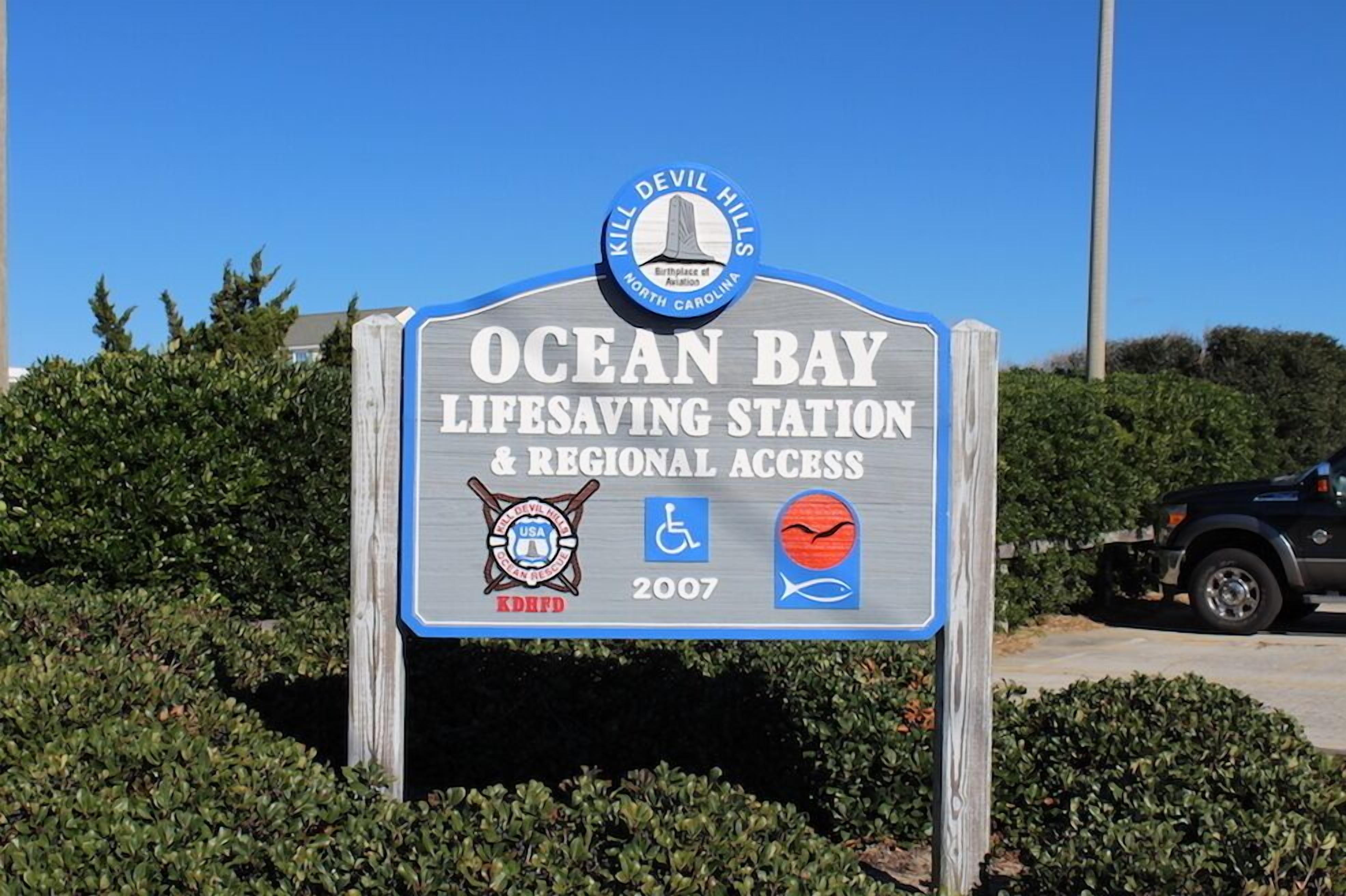 Schild einer Rettungsstation mit dem Text "Ocean Bay Lifesaving Station & Regional Access" und dem Jahr "2007".
