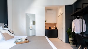 A modern hotel room with a large bed, a desk, a wardrobe, and a kitchenette. - Play Psyri, a member of Brown Hotels (Athens)