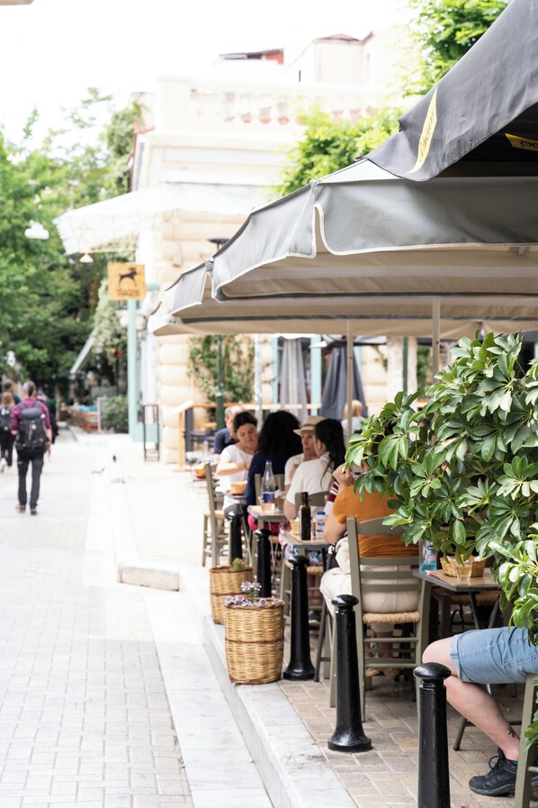 A street-side café with outdoor seating, tables, and potted plants. - Play Psyri, a member of Brown Hotels (Athens)