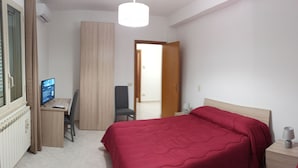 A bedroom with a bed, a desk, a chair, a computer, and a lamp. - Vacation home byron (Contessa Entellina)
