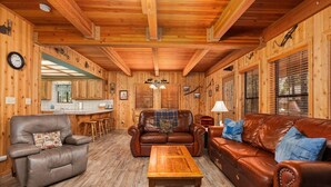 A log cabin interior with a wooden dining area, a sofa set, and a wooden coffee table. - Enjoy a relaxing family retreat in this updated 3-bedroom, 2-bath cabin in Shaver Lake’s desirable East Village. (Shaver Lake)