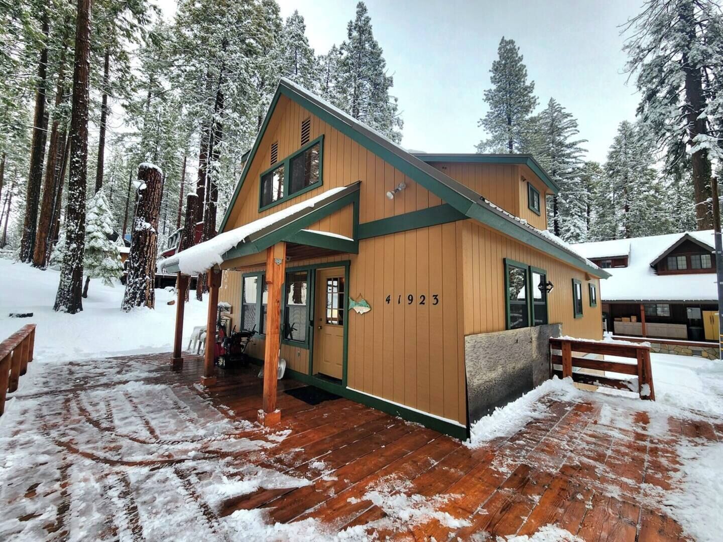 Un chalet en bois portant le numéro 41923, entouré d’arbres couverts de neige.