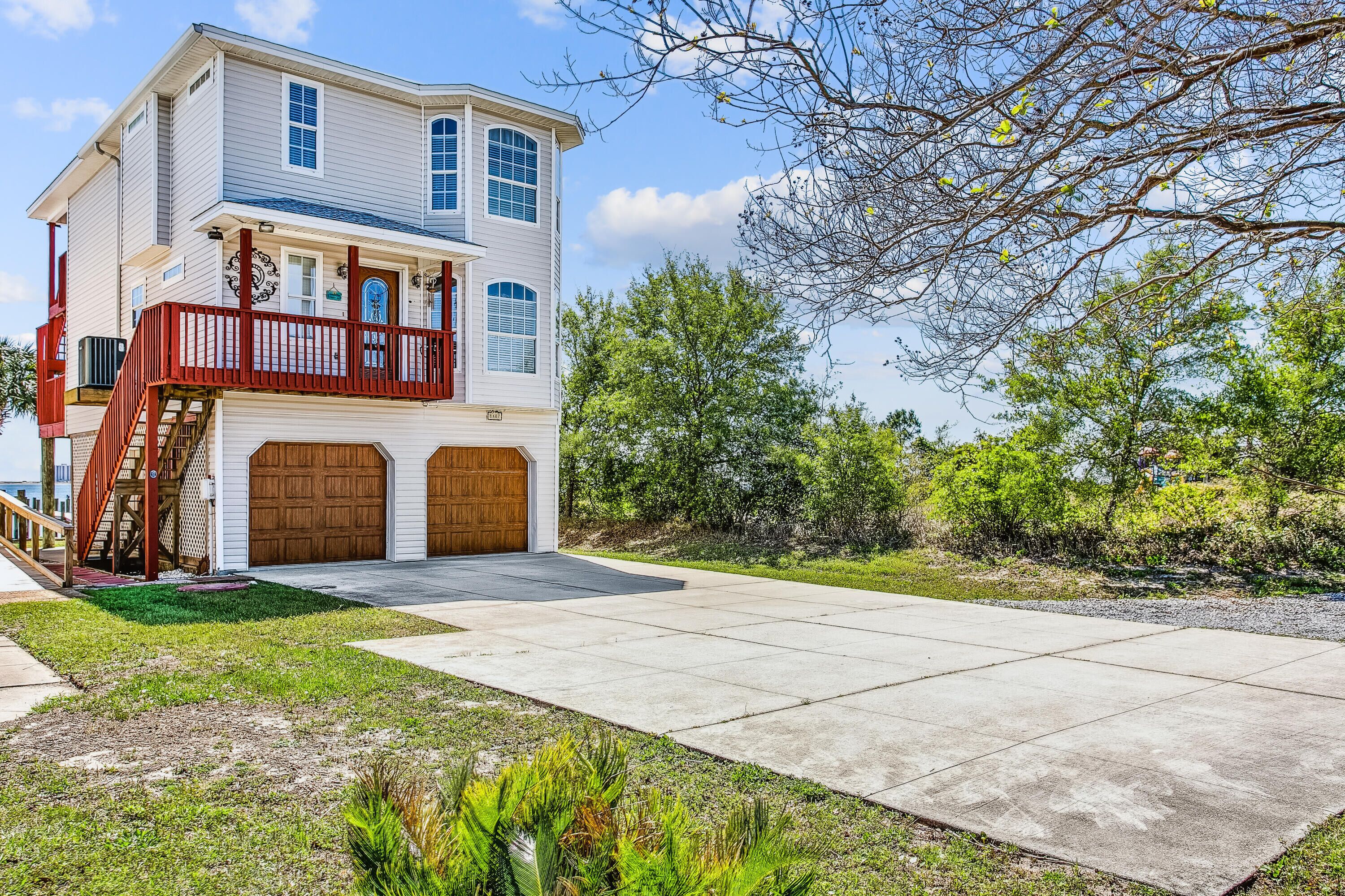 A two-story house with a front porch, a garage, and a well-maintained lawn.