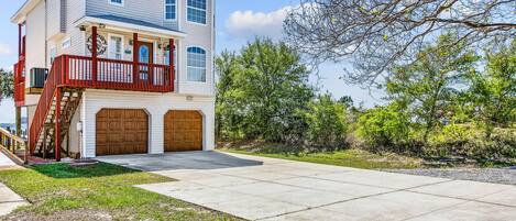 A two-story house with a front porch, a garage, and a well-maintained lawn.