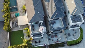 Vista aérea de un edificio residencial con piscina, varios balcones y zonas de estar al aire libre.