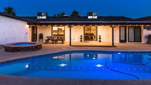 Ein Haus mit Swimmingpool, Terrasse und Sitzbereich im Freien.