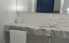 A bathroom with a marble sink, a mirror, and a towel rack. - Hotel Praia do Futuro (Fortaleza)