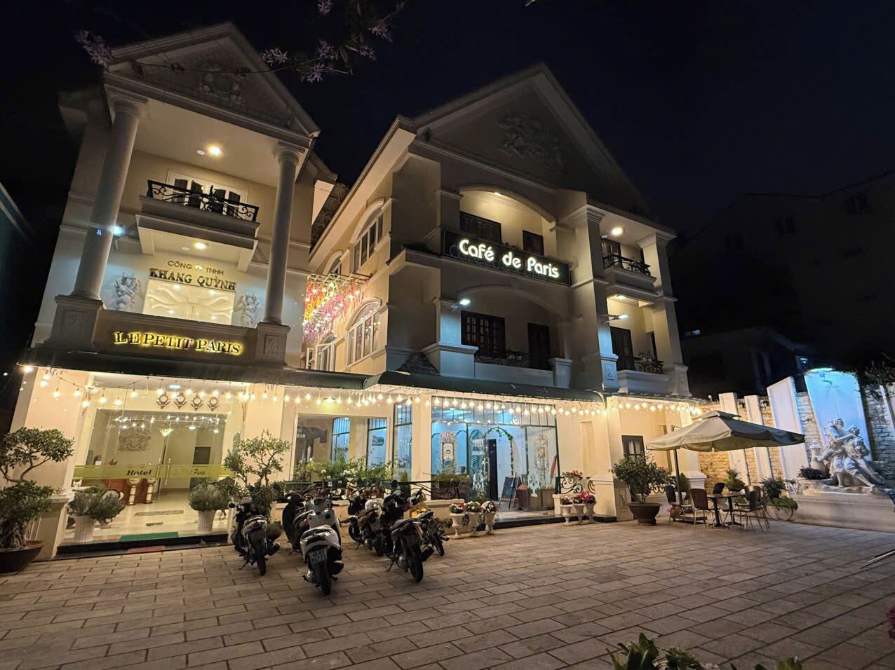 A hotel with a cafe named "Cafe de Paris" and a restaurant named "Le Petit Paris".