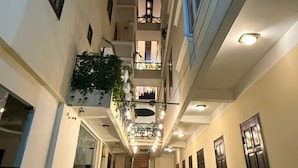 A multi-level corridor with balconies, staircases, and a green carpet. - Le Petit Paris Hotel  (Cam Ly - Da Lat)