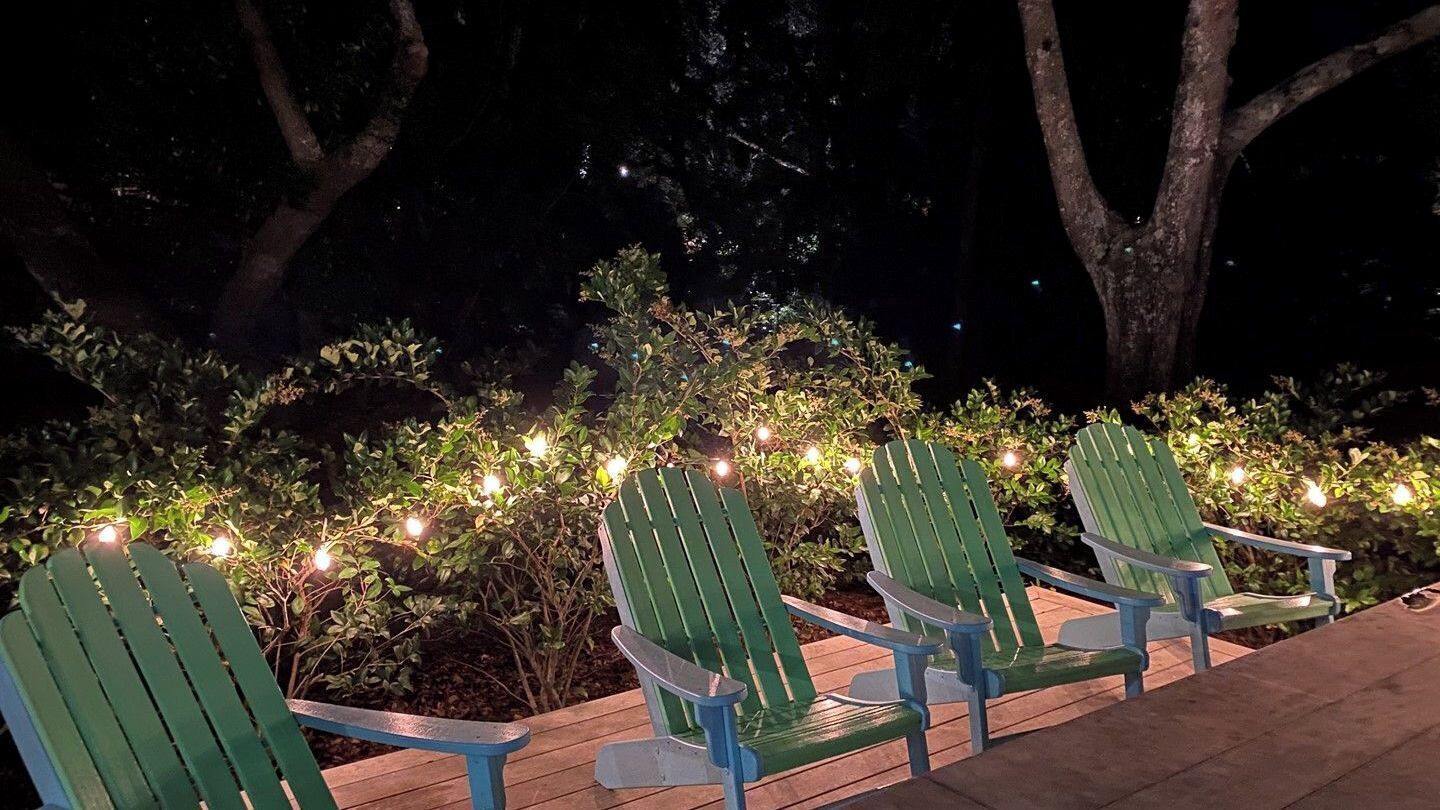 Espace extérieur aménagé avec des chaises et des guirlandes lumineuses.
