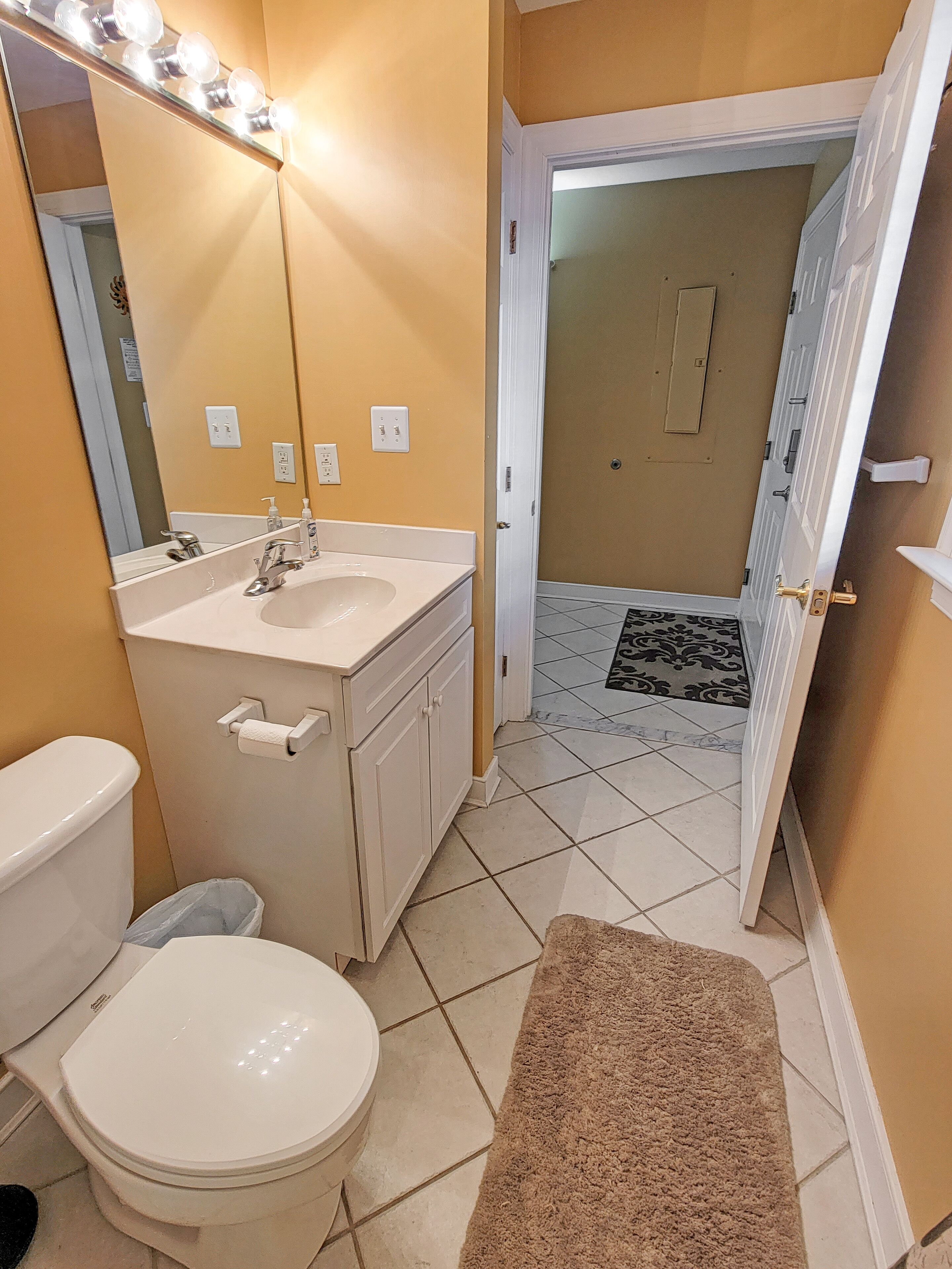 Une salle de bain avec un lavabo, un miroir et des toilettes.
