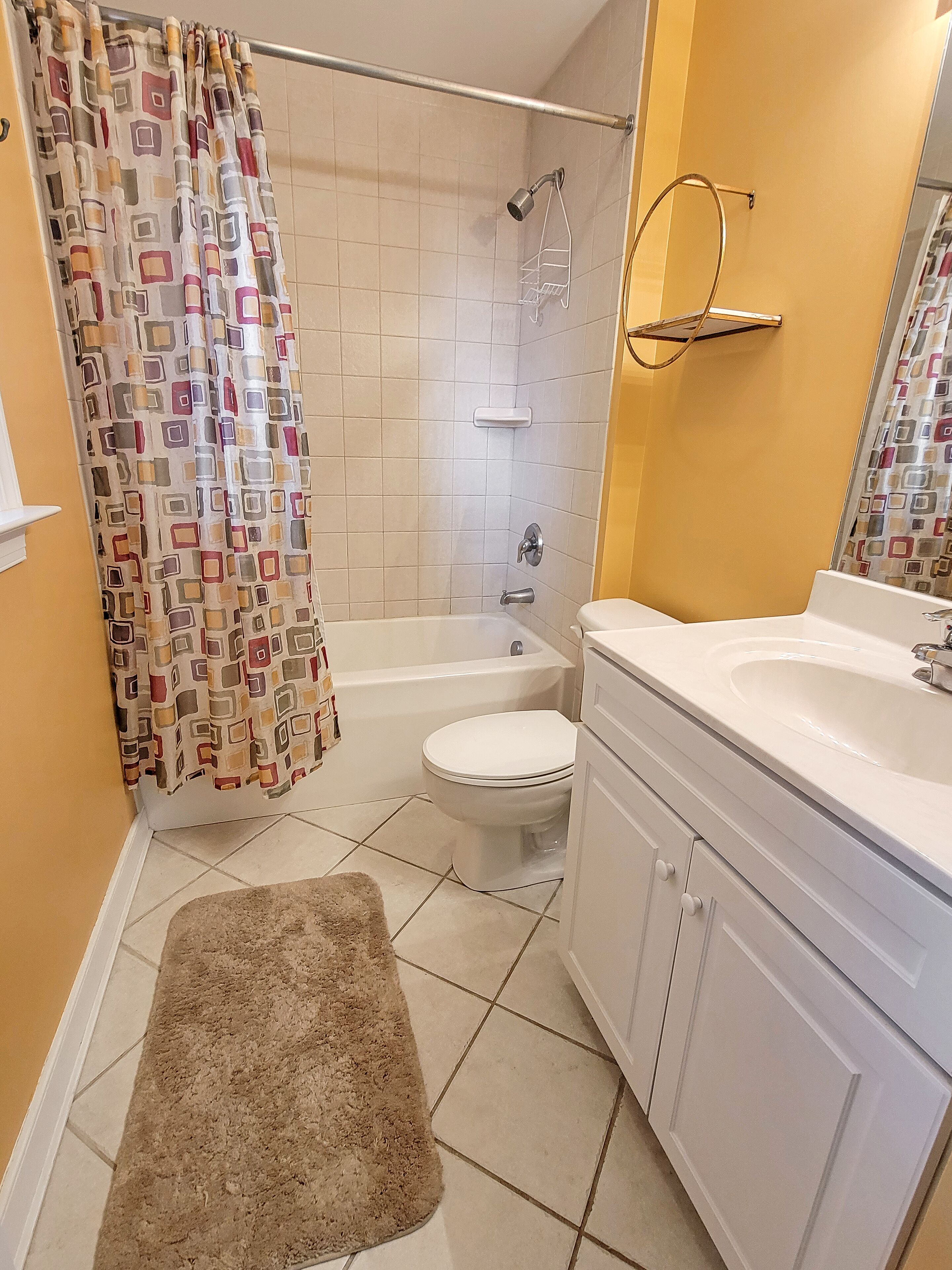 A bathroom with a shower, toilet, and sink.