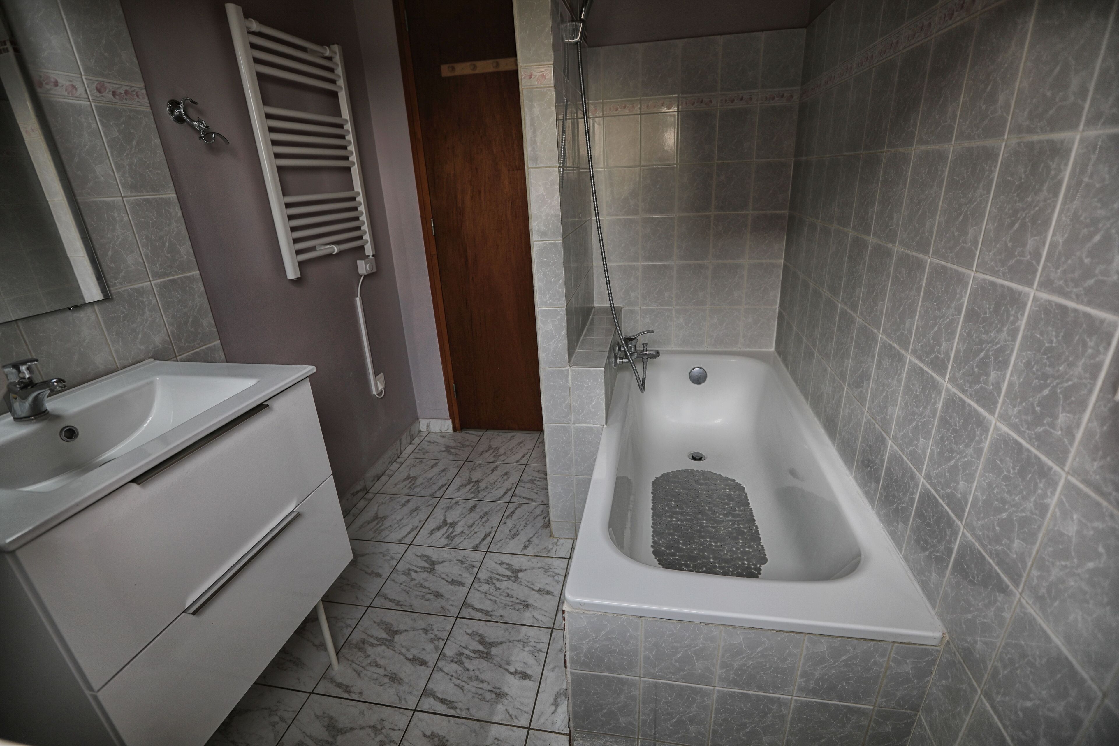 Un baño con bañera, lavamanos y espejo.