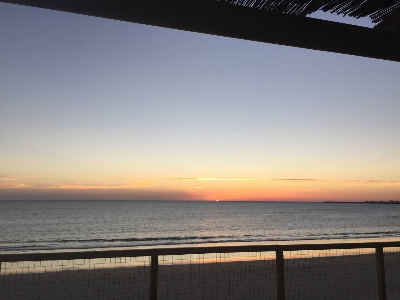 A coastal view with a clear sky, a calm sea, and a distant horizon.