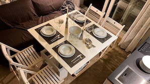 A dining area with a table set for four, including plates, cutlery, and glasses. - Guest house on the beach in La Torre Verde (El Puerto de Santa María)