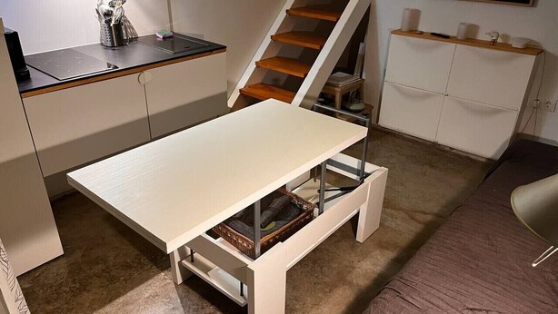 A compact living space with a foldable table, a staircase, and a small kitchenette. - Guest house on the beach in La Torre Verde (El Puerto de Santa María)
