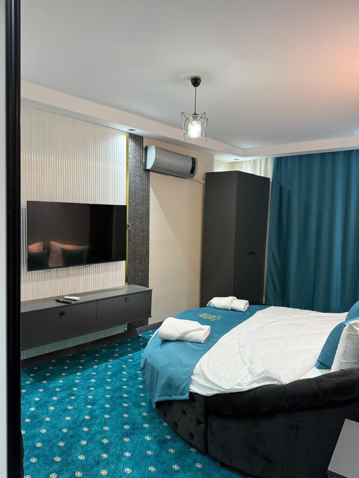 Une chambre d’hôtel moderne équipée d’un lit, d’une télévision à écran plat, d’un bureau et d’une armoire.