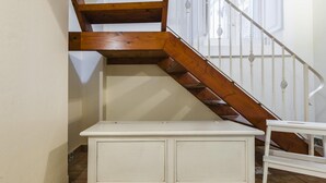 A staircase with wooden steps and white balustrades, leading to an upper floor.