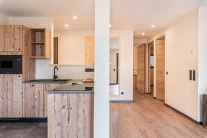 Une cuisine moderne avec des meubles en bois et un four encastré.