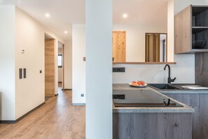 Une cuisine moderne dotée d’une cuisinière intégrée, de meubles en bois et d’un évier.